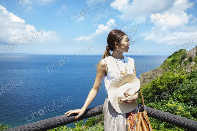 Japanese woman standing on a cliff,ocean in the background.