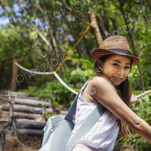 Japanese woman wearing hat hiking in a forest. Japanese woman wearing hat hiking in a forest.