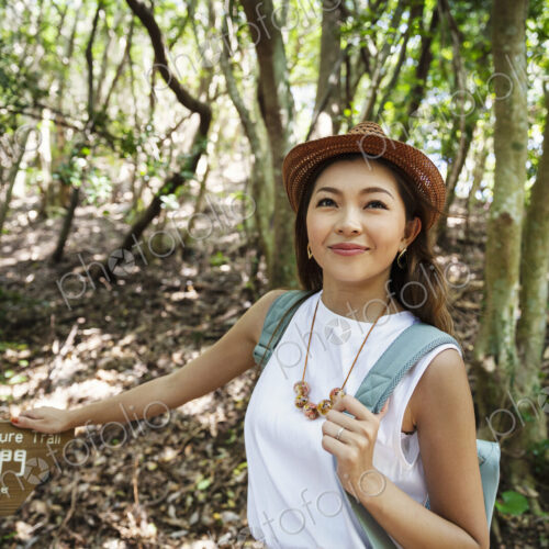 Japanese woman wearing hat hiking in a forest. Japanese woman wearing hat hiking in a forest.