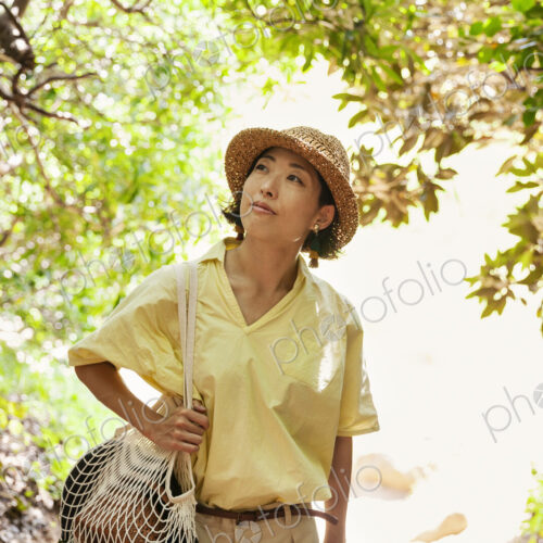 Japanese woman wearing hat hiking in a forest. Japanese woman wearing hat hiking in a forest.