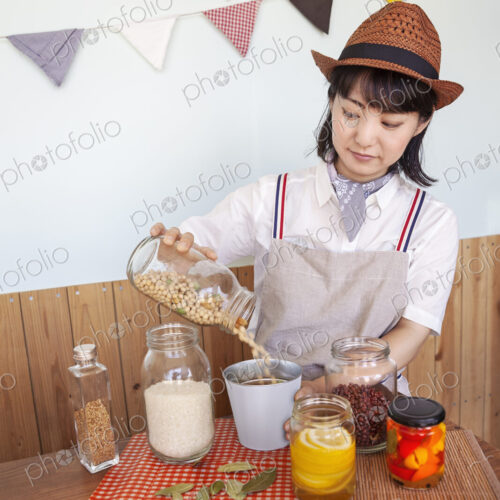 Japanese woman wearing hat standing in a farm shop with a selection of foods and… Japanese woman wearing hat standing in a farm shop with a selection of foods and…