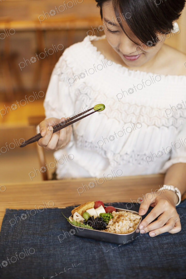 Japanese women eating with chopsticks in a vegetarian cafe.