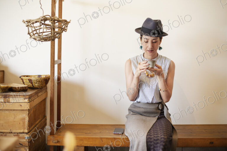 Japanese women wearing hat drinking tea in a vegetarian cafe.