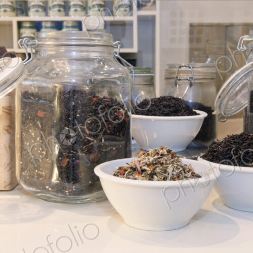 Jars and cups filled with various blends of tea on the counter of a lunchroom. Jars and cups filled with various blends of tea on the counter of a lunchroom.