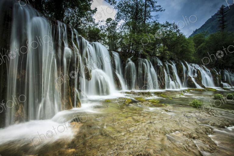 Jiuzhaigou Waterfall, water cascading over rocks in a national park, an Unesco world…