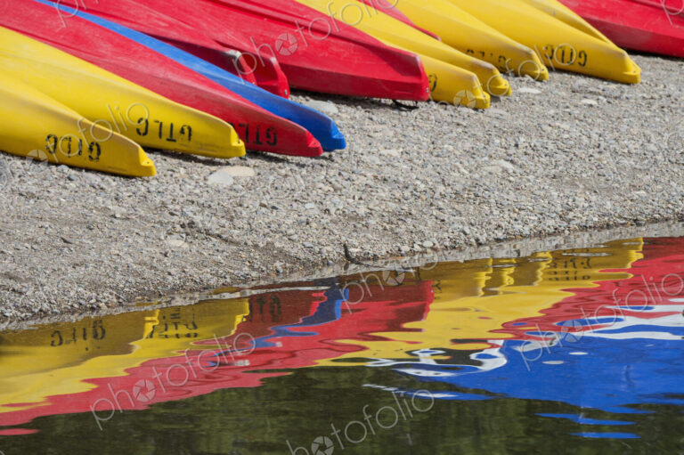 Kayaks for hire, laid out on the shores of Colter Bay at Jackson lake in the Grand…