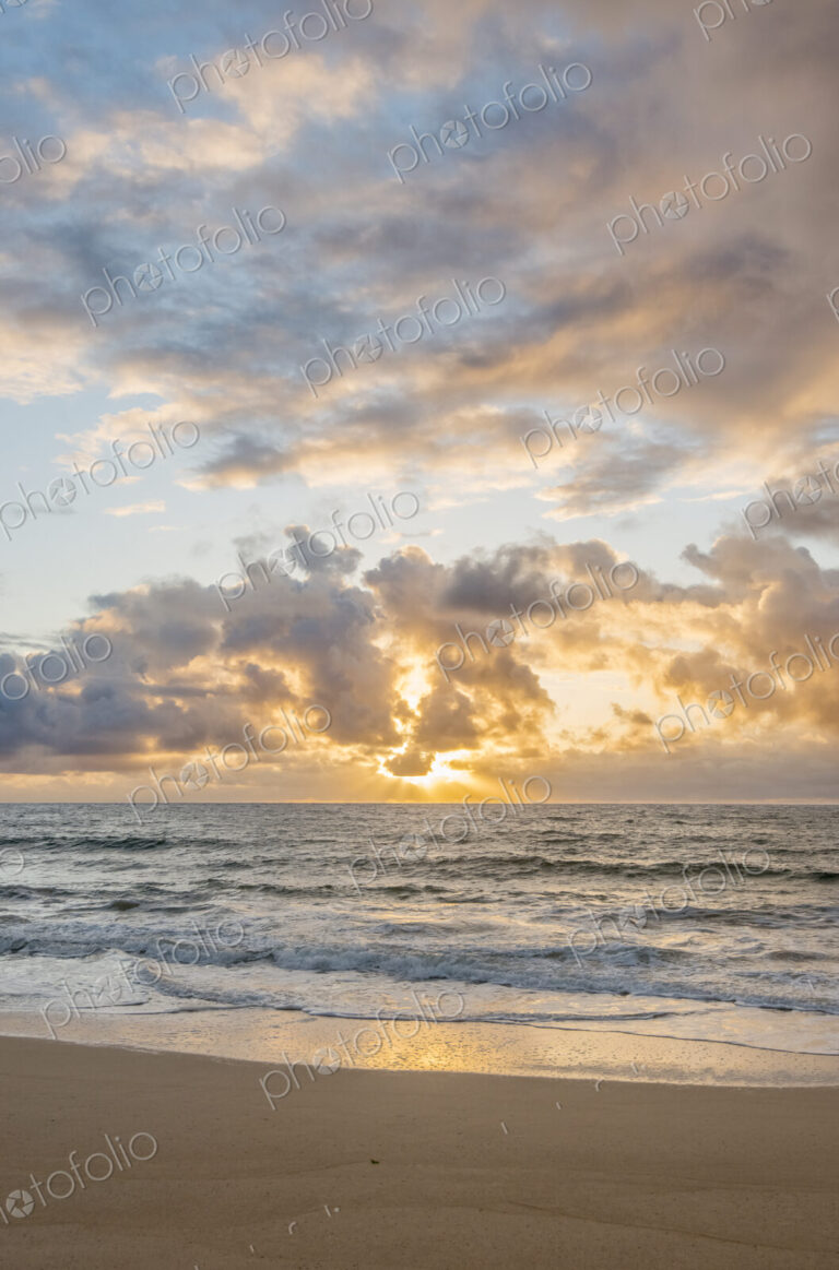 Kealia Beach, Kauai, sunrise view from the beach, clouds lit up by sunlight.