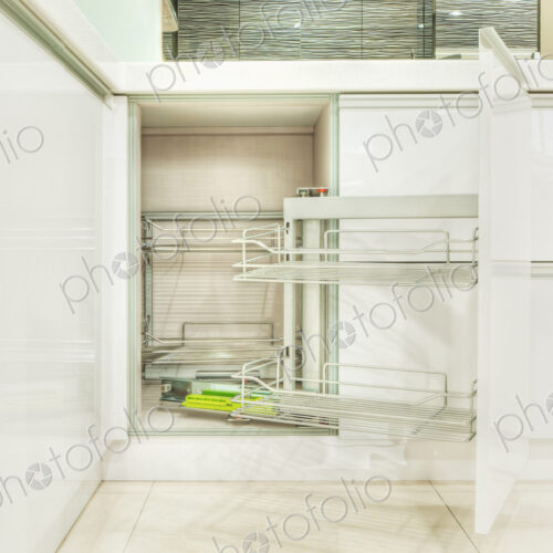 Kitchen cupboard with stainless steel metal racking, microwave oven and a stainless…