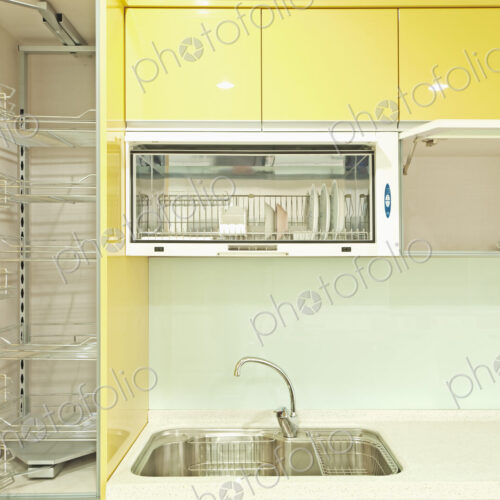 Kitchen cupboard with stainless steel metal racking, microwave oven and a stainless…