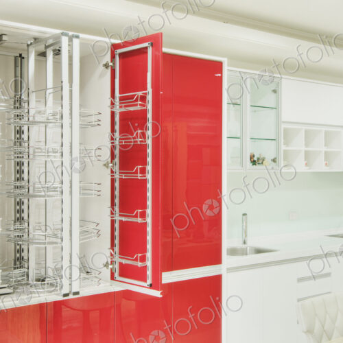Kitchen cupboard with stainless steel metal racking, microwave oven and a stainless…