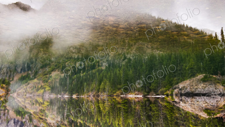 Lake Angeles, reflections in the water surface of the lake, tall trees and wooded…