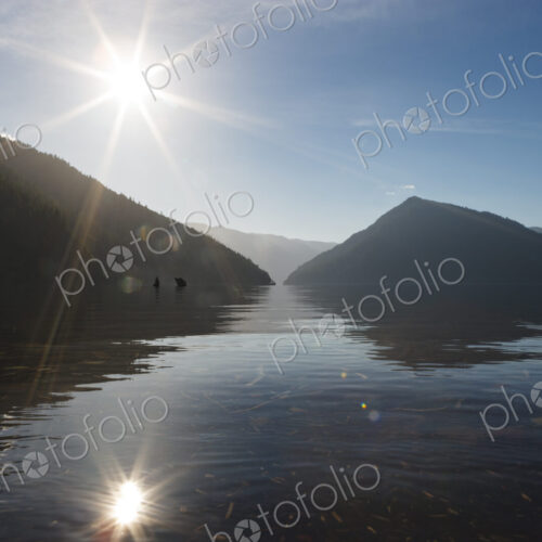 Lake Crescent, Olympic National Park, lens flare, sun in the sky above the water,… Lake Crescent, Olympic National Park, lens flare, sun in the sky above the water,…