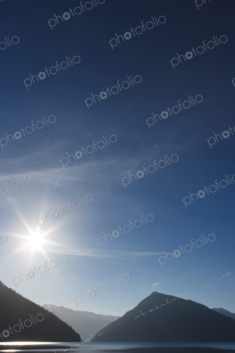 Lake Crescent, Olympic National Park, sun in the sky and silhouettes of the hills…