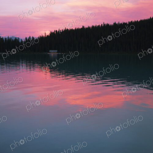 Lake Louise with reflections of pink sky at sunset. Lake Louise with reflections of pink sky at sunset.