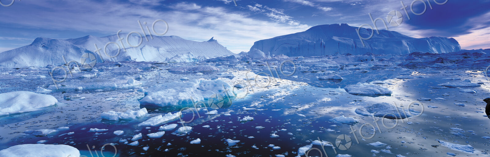 Landscape with icebergs and ice sheets on the ocean.