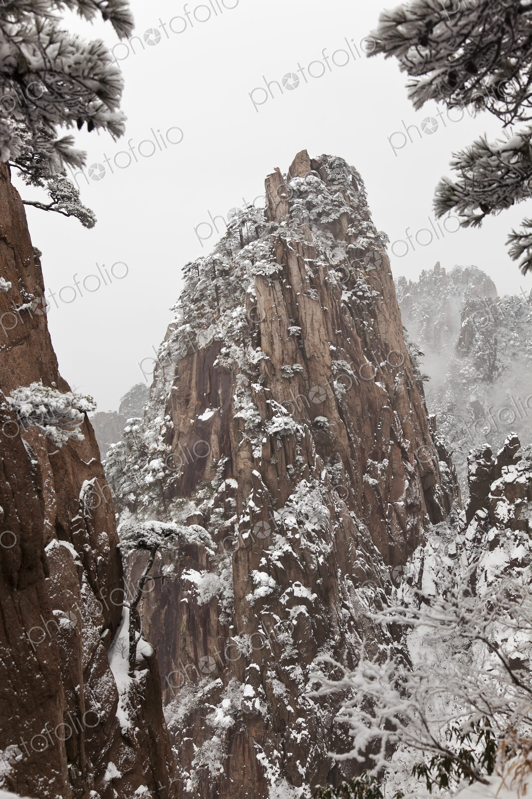 Landscape with snow-capped narrow steep mountain.