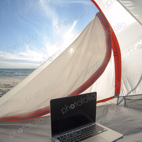 Laptop in camping tent on beach Laptop in camping tent on beach
