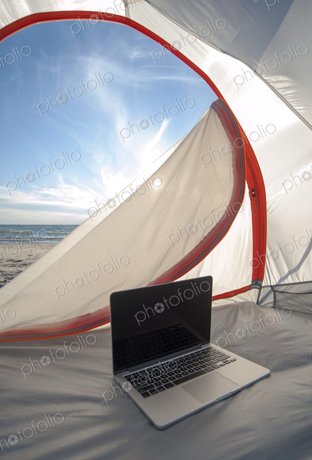 Laptop in camping tent on beach