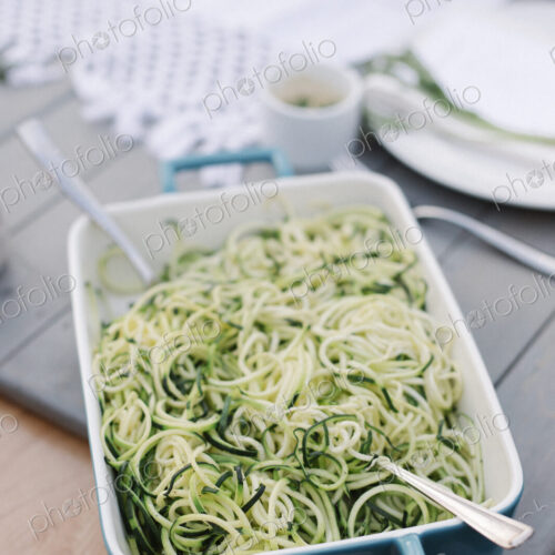 Large dish with a salad on a table in a garden.
