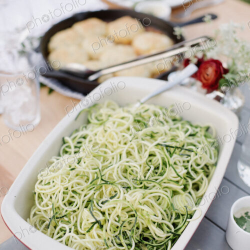 Large dish with a salad on a table in a garden.