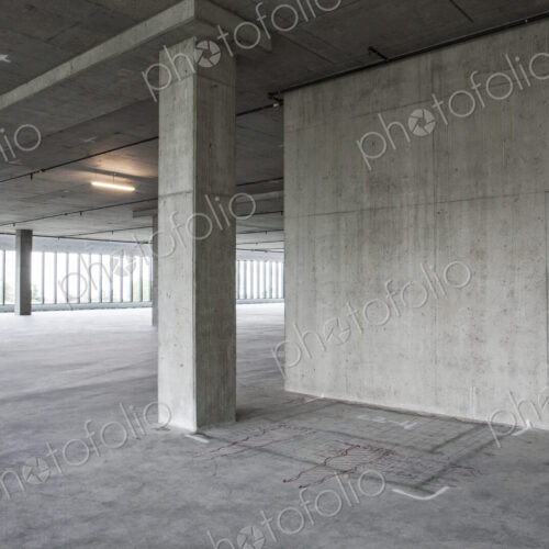 Large empty raw office space with plans sketched onto the floor in chalk.