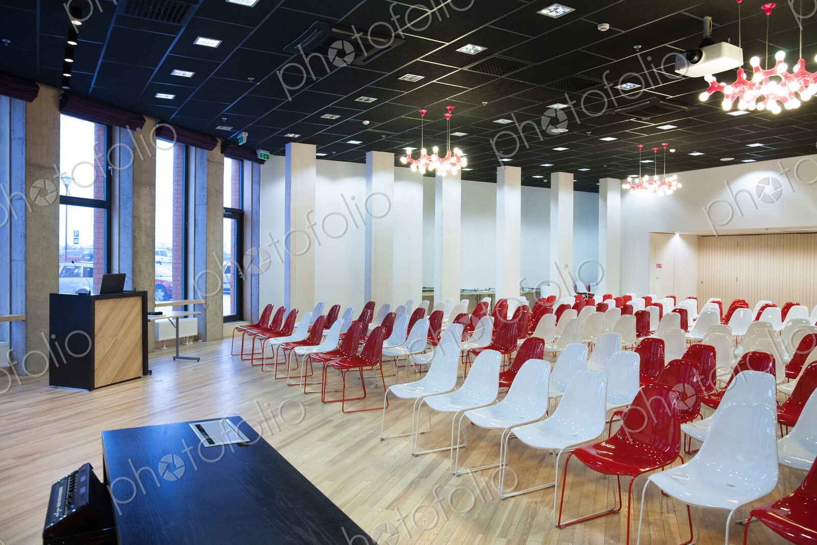 Large empty room with red and white chairs in rows, ready for a presentation