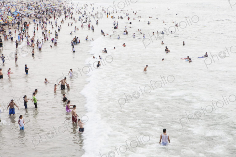Large group of people swimming in the ocean at Santa Monica, California.