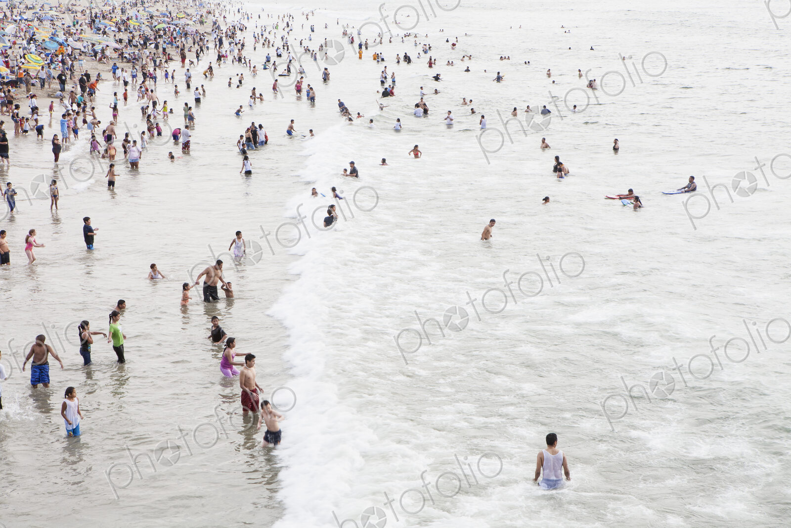 Large group of people swimming in the ocean at Santa Monica, California.