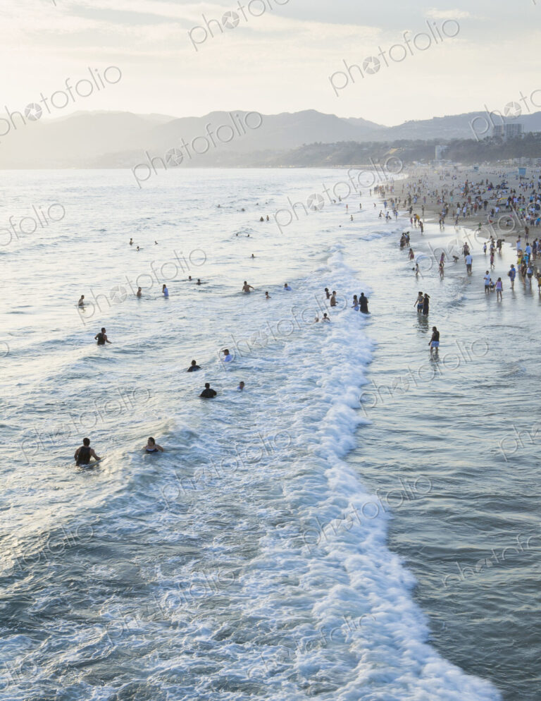 Large group of people swimming in the ocean at Santa Monica, California.
