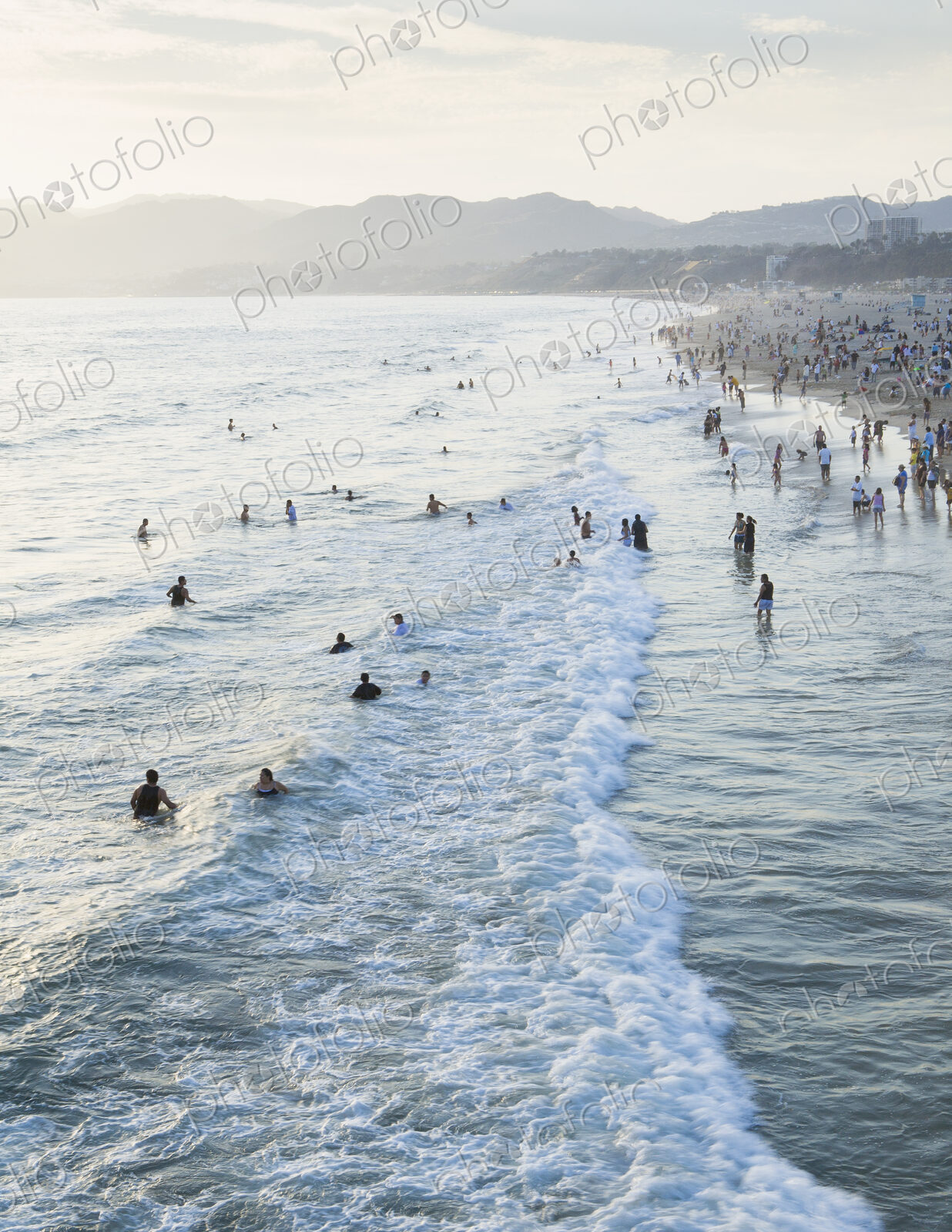 Large group of people swimming in the ocean at Santa Monica, California.