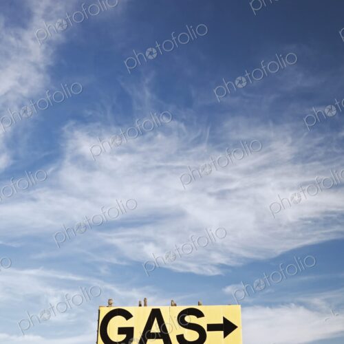 Large roadside GAS arrow sign on a weathered wooden billboard stands in a rural… Large roadside GAS arrow sign on a weathered wooden billboard stands in a rural…