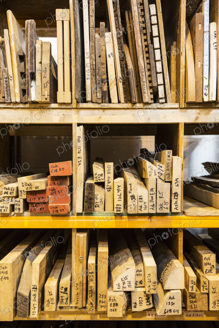 Large selection of wooden planks and boards stacked on shelves in a warehouse.