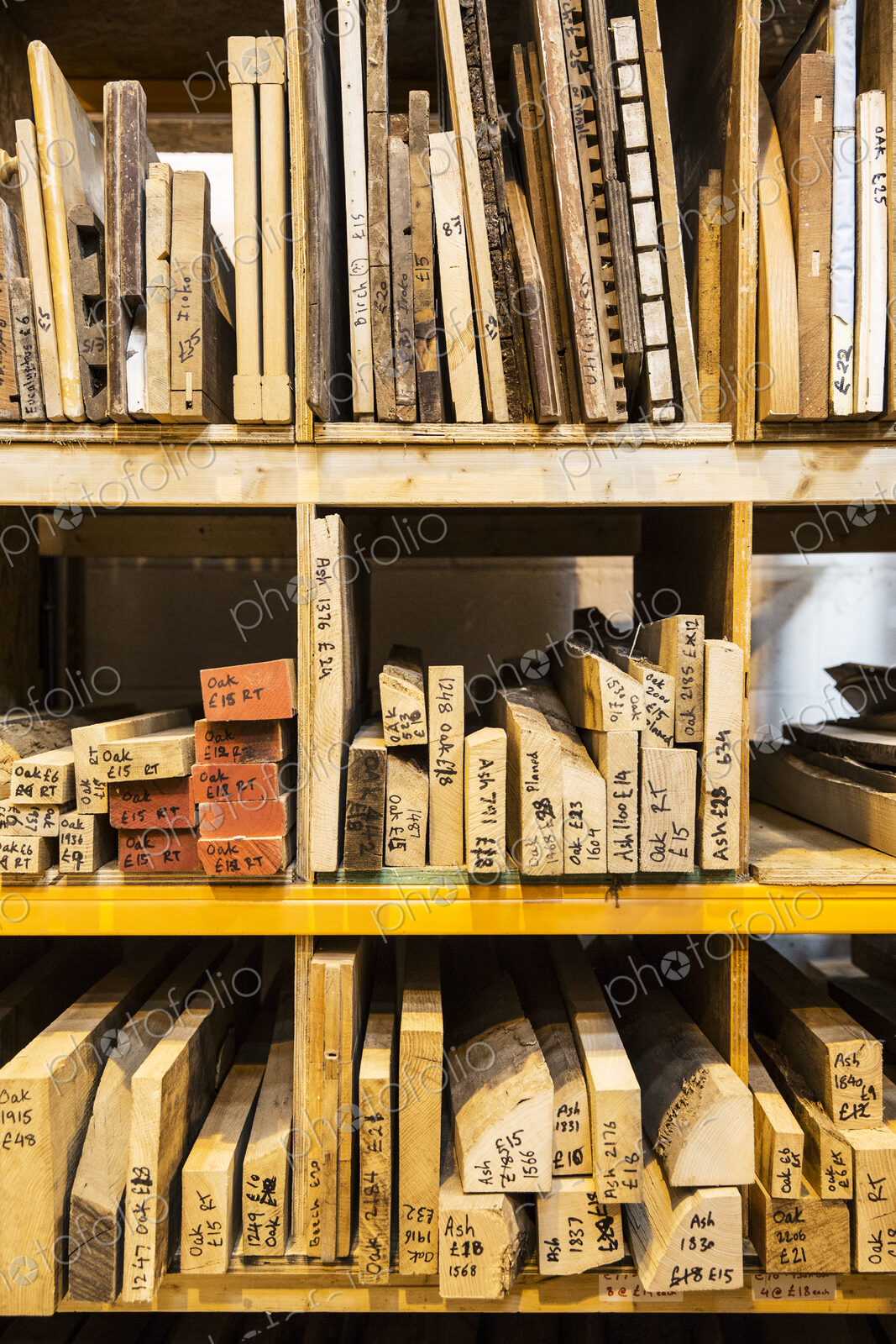 Large selection of wooden planks and boards stacked on shelves in a warehouse.