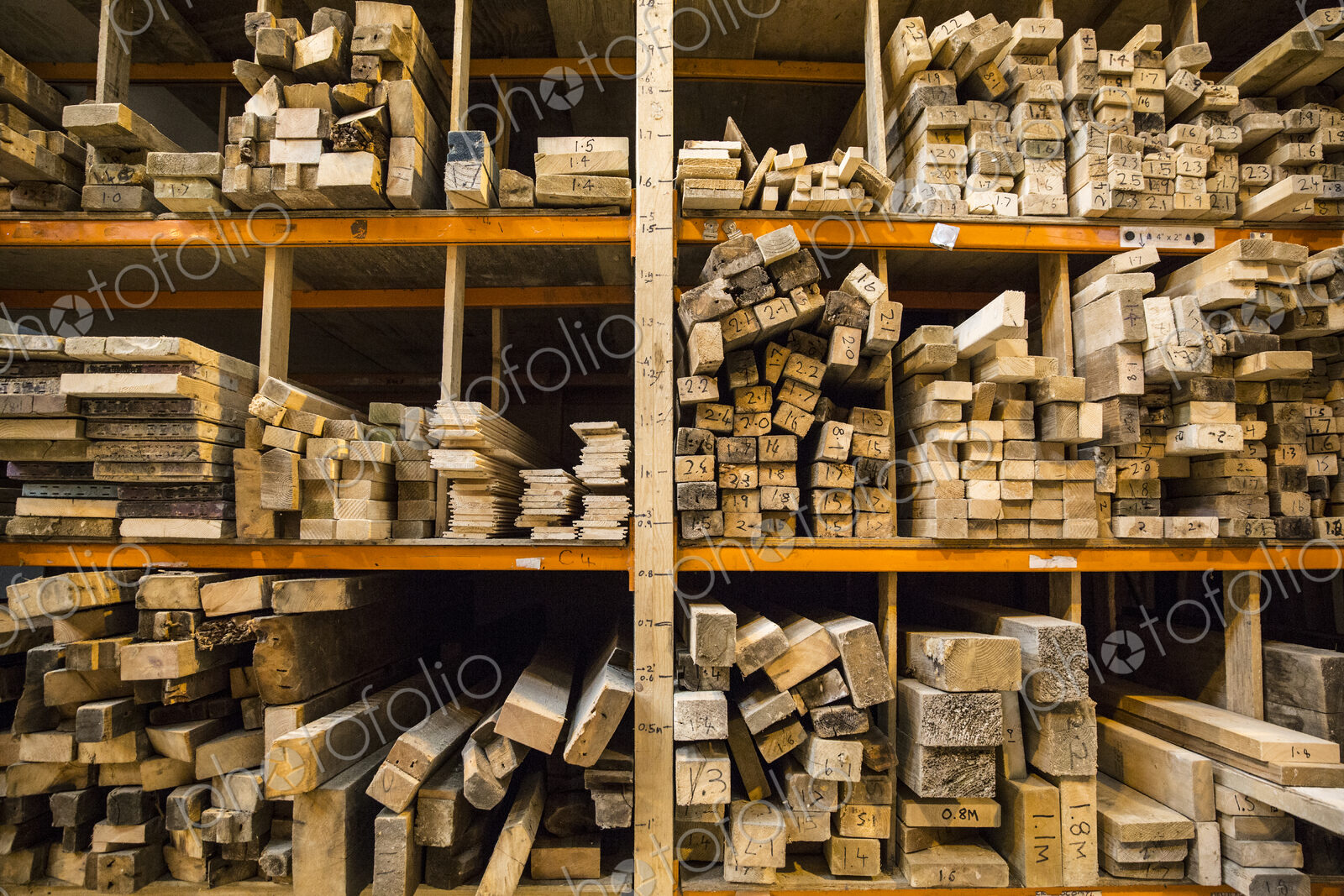Large selection of wooden planks stacked on shelves in a warehouse.