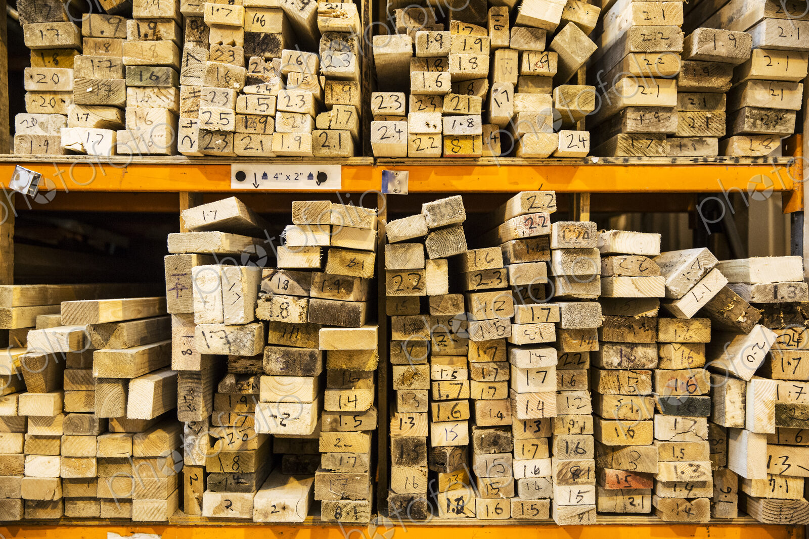 Large selection of wooden planks stacked on shelves in a warehouse.