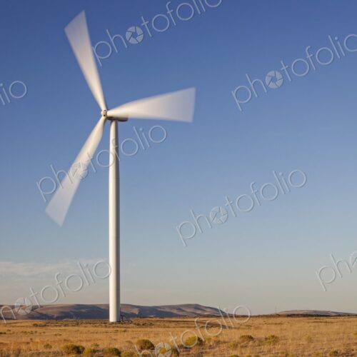 Large wind turbine spins in an open Oregon landscape with clear blue sky and golden… Large wind turbine spins in an open Oregon landscape with clear blue sky and golden…
