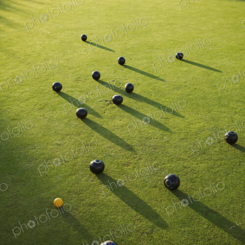 Lawn bowls balls positioned on a smooth playing surface, a bowls green. One small… Lawn bowls balls positioned on a smooth playing surface, a bowls green. One small…