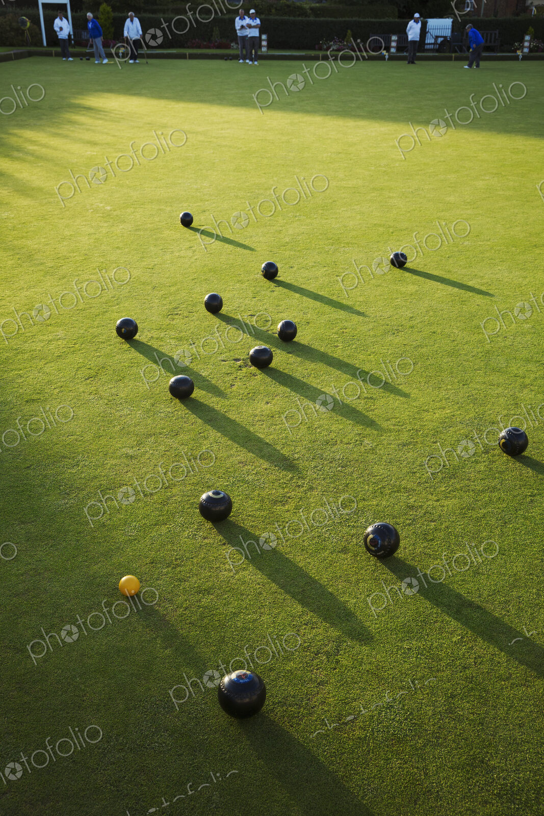 Lawn bowls balls positioned on a smooth playing surface, a bowls green. One small…
