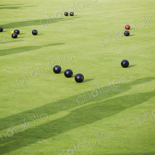 Lawn bowls balls scattered on the playing surface, two very close to the target jack… Lawn bowls balls scattered on the playing surface, two very close to the target jack…
