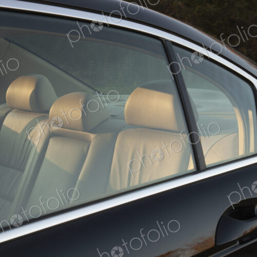 Leather backseat of a car viewed through side window. Leather backseat of a car viewed through side window.