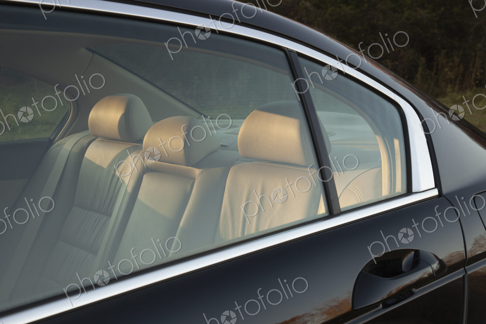 Leather backseat of a car viewed through side window.