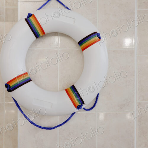Life preserver, life ring on a wall in an indoor swimming pool.