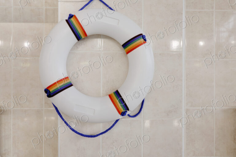 Life preserver, life ring on a wall in an indoor swimming pool.