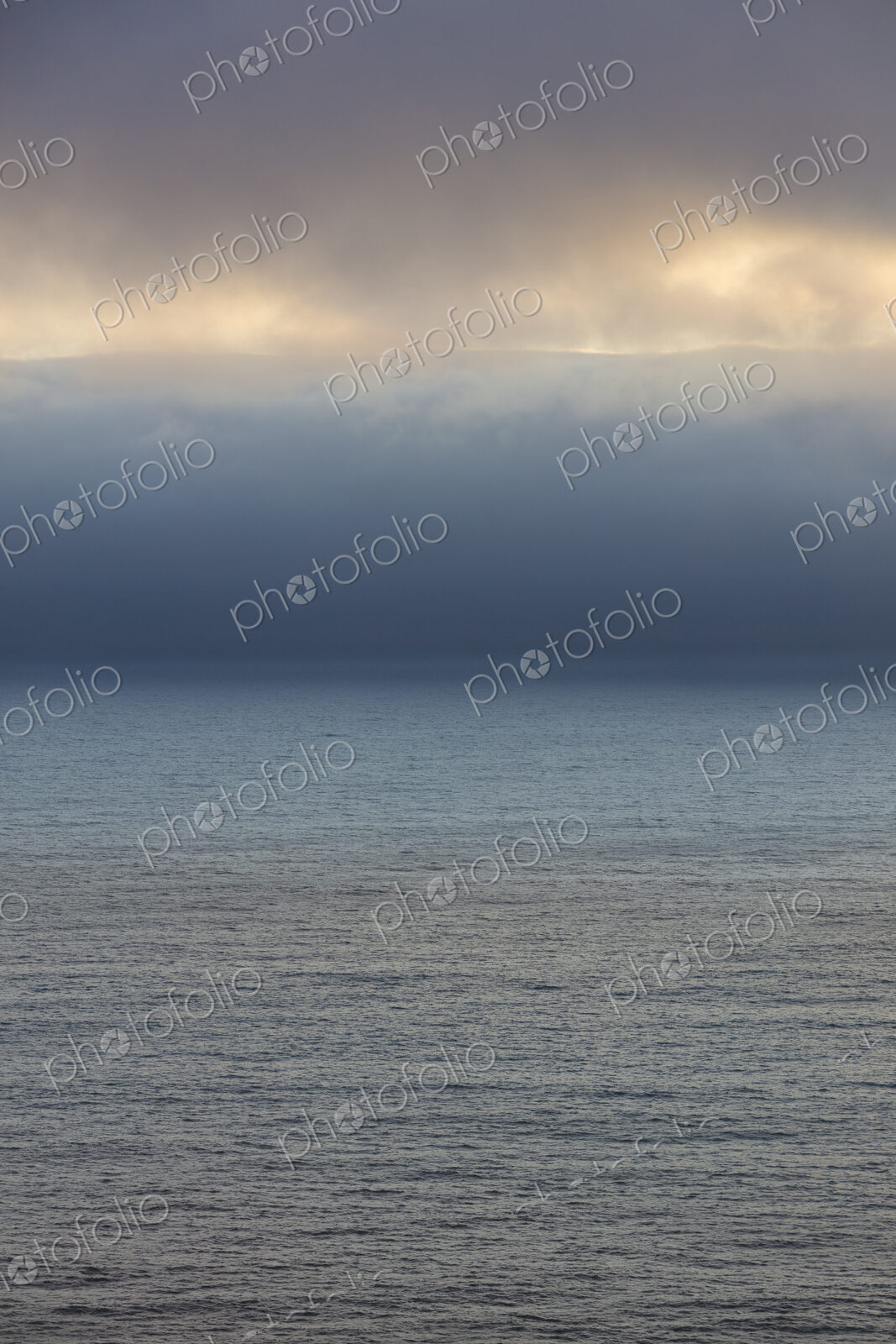 Lifting clouds and fog over vast ocean