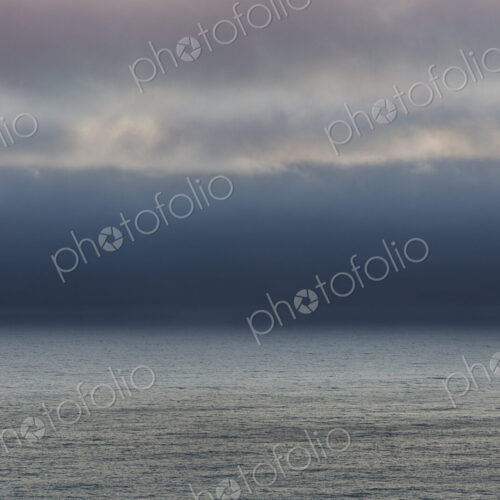 Lifting clouds and fog over vast ocean