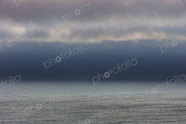 Lifting clouds and fog over vast ocean