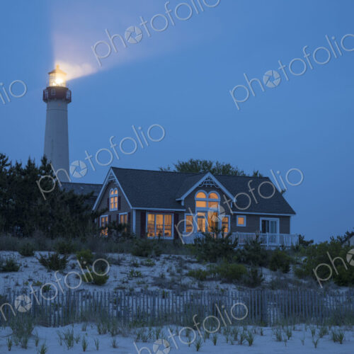 Lighthouse beaming near beach house