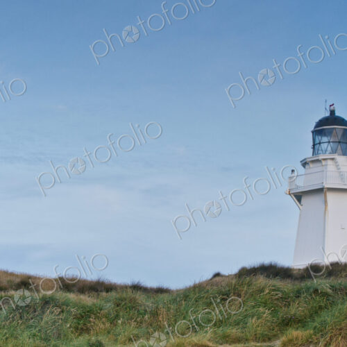 Lighthouse under moon in blue sky