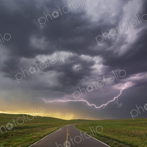 Lightning on the horizon at North Prairie Trace Road, black stormy sky over the land. Lightning on the horizon at North Prairie Trace Road, black stormy sky over the land.