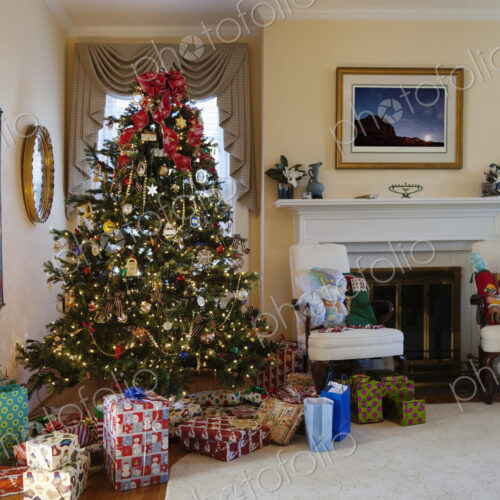 Living room with Christmas tree and gifts, traditional decorations, fireplace and… Living room with Christmas tree and gifts, traditional decorations, fireplace and…